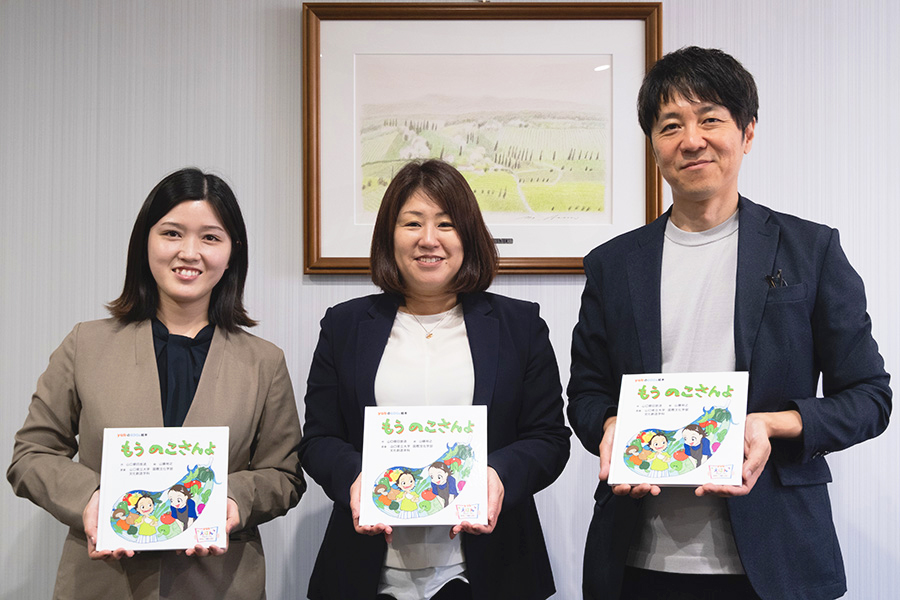 画像:絵本を持って並ぶ社員